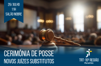 Recorte fotográfico de um Tribunal, desfocado em tons de marrom e dourado, com um martelo de juiz em primeiro plano. No canto superior esquerdo, bandeirola azul escura com as informações do evento em letras brancas. Abaixo, tarja azul escura desfocada na parte de cima, onde se lê CERIMÔNIA DE POSSE NOVOS JUÍZES SUBSTITUTOS em letras brancas, à esquerda. No lado direito da tarja, vê-se a logomarca do TRT-16.