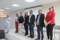 Imagem mostra juíza titular da Vara do Trabalho de Barreirinhas, Liliana Bouéres, ladeada de autoridades, posicionadas em um plano elevado, de fundo claro. 