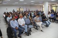 Imagem mostra pessoas, representantes de diversas instituições sentadas em um auditório. Local bem iluminado com paredes claras. 