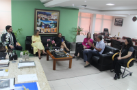 Imagem da presidente do TRT16 desa. Márcia Andrea Farias no gabinete ouvindo o arquiteto César Cardoso, acompanham a reunião, servidores da alta direção. Todos estão sentados