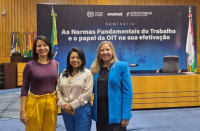 Foto mostra as juízas Carolina Burlamaqui (substituta na 6ª VT em São Luís e coordenadora pedagógica da Ejud16),  Liliana Boueres (titular da VT de Barreirinhas) e Angelina Moreira de Sousa Costa – substituto na 3ª VT em São Luís). Ao fundo o painel com o nome do seminário “As Normas Fundamentais do Trabalho e o papel da OIT na sua efetivação”.