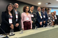 Foto mostra 9 pessoas, entre homens e mulheres em pé atrás de uma bancada.