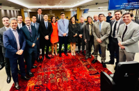 Foto mostra um grupo de pessoas em pé. 