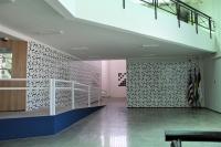 Foto mostra, o átrio do hall de entrada no plenário do TRT-16. Ao fundo, um mural de azulejos personalizados, inspirados no símbolo da Justiça do Trabalho. Na parte esquerda, uma rampa de acessibilidade. 