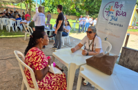 Foto mostra duas mulheres sentadas à mesa. Ao fundo um banner com a informação: Pop Rua Jud Maranhão