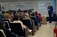 Foto mostra um homem realizando uma palestra em um auditório. Muitas pessoas estão sentadas.