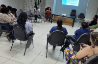 Foto mostra um grupo de pessoas reunidas em uma roda de conversa.