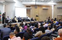 Foto de auditório com plateia e autoridades no palco.
