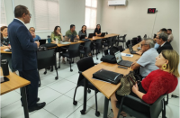 Foto mostra um homem ministrando capacitação em uma sala de treinamento.