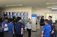 Foto mostra várias pessoas dentro de uma sala conversando.