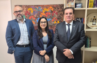 Foto de dois homens e uma mulher de pé e sorrindo.