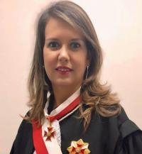 Imagem de uma mulher sorrindo, usando toga.