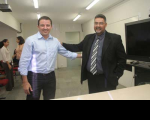 Diretor geral, Júlio César Guimarães ( de terno), cumprimenta Henrique Mota, primeiro servidor empossado na tarde