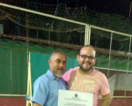 JUiz Carlos Eduardo entrega o certificado ao representante de uma das escolas