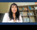 Imagem da servidora Edvania Katia vestido roupa rosa tendo ao fundo uma estante com livros