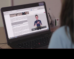 Imagem de mulher de costas ao computador vendo página acessível.