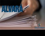 Imagem com mão segurando papéis, onde se lê: ALVARÁ