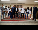 Foto em que estão o presidente do Tribunal Superior do Trabalho, ministro Emmanoel Pereira, ladeado por dez jovens, entre eles, o representante do Centro Salesiano do Adolescente Trabalhador, e pelo ministro Lelio Bentes Corrêa sobre tapete estampado com predominância da cor vermelha, numa sala com paredes claras