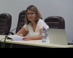 Foto da desembargadora Márcia Andrea, do TRT do Maranhão, cabelos claros, usando óculos, vestindo roupa branca, sentada à mesa, centralizada, no auditório da Escola Judicial, durante abertura da 17ª Semana de Formação de Magistrados