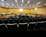 Foto do Pleno do Tribunal Superior do Trabalho, em Brasília, onde se vê quatro bancadas de madeira, das quais duas laterais (maiores) e duas no centro, onde ficam sentados ministros e ministras do TST, servidores, membros do Ministério Público do Trabalho, além de cadeiras onde ficam sentados as partes processuais, advogados e advogadas; as paredes são revestidas de madeira na mesma cor das bancadas; o teto com várias luminárias.