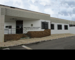 Foto da fachada principal da Vara do Trabalho de Balsas, no Estado do Maranhão. No primeiro plano, entrada de acesso à VT por uma escada preta e porta de vidro escura. A fachada tem paredes brancas, janelas de vidro com grades pretas e outros detalhes em lajota e pedras. Tem o brasão do Poder Judiciário fixado na parede, está escrito ao lado: Tribunal Regional do Trabalho da 16ª Região - Vara do Trabalho de Balsas