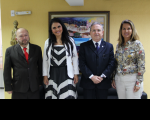 Foto posada de 2 homens e 2 mulheres à frente de parede amarela com quadro colorido.