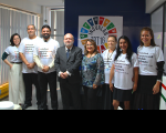 Foto de homens e mulheres em pé na frente de uma parede azul onde está a marca do INOVALAB TRT16