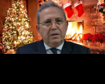 homem de terno com árvore de natal e lareira ao fundo