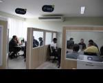 Duas salas de audiências do centro de conciliação da Justiça do Trabalho em São Luís com pessoas sentadas em torno de mesas. Salas são separadas por paredes reduzidas e amplas janelas de vidro.