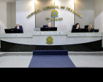 plenário composto por uma extensa mesa composta por quatro pessoas. Ao fundo, brasão da república com a inscrição "Tribunal Regional do Trabalho da 16ª região