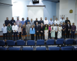 Trinta pessoas reunidas, posando para a foto, em ambiente de auditório.