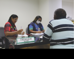 Duas mulheres e um homem sentados durante triagem para vacinação