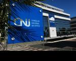 Fachada de edifício da sede do Conselho Nacional de Justiça. No primeiro plano, painel com o nome do CNJ.