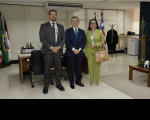Três pessoas em pé posando para a foto dentro de um gabinete, sendo dois homens e uma mulher. 