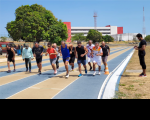 Fotos de vários homens e de uma mulher vestindo roupas esportivas, que estão correndo numa pista de atletismo. À direita, há um homem em pé vestindo roupas pretas cronometrando a atividade.