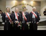 Quatro pessoas posam para foto dentro de um plenário, dois homens e duas mulheres. Todos vestidos com toga.