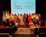 Grupo de pessoas posando para foto dentro de um auditório. Ao fundo, tela projetada com texto escrito ZENABIJUD, ENCONTRO NACIONAL DE BIBLIOTECAS DO PODER JUDICIÁRIO.