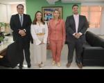 Quatro pessoas, duas mulheres ao centro e dois homens, posando para foto dentro de uma sala.