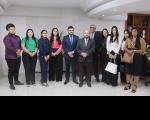 Onze pessoas posando para a foto, posicionados lado a lado, dentro de uma sala.