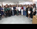 Grupo de mulheres posando para foto dentro de uma sala.