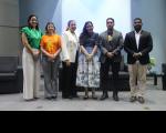 Seis pessoas posando para foto dentro de um auditório. Quatro mulheres e dois homens.