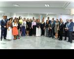 Grupo de pessoas posando para foto dentro de um auditório.