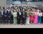 Pessoas em pé, posando para foto, dentro de um auditório.