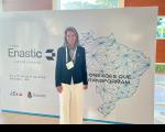 Foto mostra a presidente do TRT-16 desa. Márcia Andrea Farias da Silva posicionada diante de um painel do ENASTIC. 