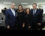 Foto mostra duas mulheres ao centro e dois homens nas extremidades. Eles estão em pé, diante de cadeiras de um auditório