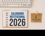 Arte com fundo cor de areia, tendo ao topo parte do teclado. Abaixo dele, um calendário de mesa com espiral, onde se lê CALENDÁRIO INSTITUCIONAL 2026. À direita, clipe rosado segurando uma folhinha de papel pardo, onde aparece a logomarca do TRT-16.