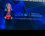Foto mostra uma mulher segurando um troféu de acrílico. Ao lado a informação. J.Ex. Prêmio de Inovação
