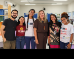Foto mostra seis pessoas, uma ao lado da outra, em pé, dentro de uma sala de aula. Alguns são estudantes com o uniforme do IEMA