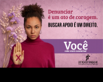 Arte com fundo rosa e ramalhete de flores roxas desidratadas à esquerda. Ao lado das flores, foto de uma mulher negra, usando coque e blusa pink de mangas compridas, com a mão direita levantada exibindo um X pink. À direita, textos da campanha e logomarca do TRT-16.