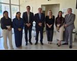 Foto mostra um grupo de pessoas em pé dentro de uma sala